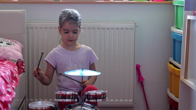 可爱的小女孩正在玩鼓玩具