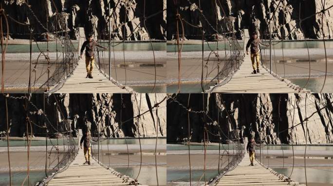 在喜马拉雅山脉吊桥上行走的男子
