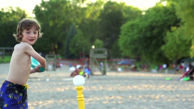 男孩在海滩打棒球的慢动作