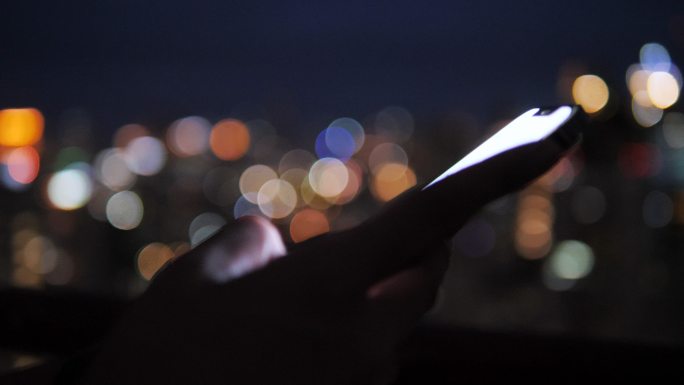 嬉皮士在城市夜晚使用智能手机