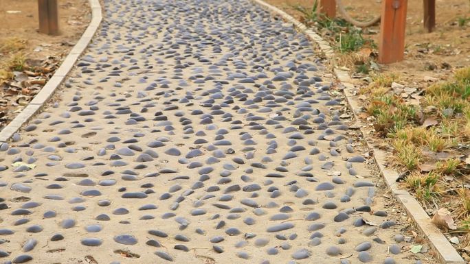 公园一条石子路两边是棕黄色的护栏非常好看