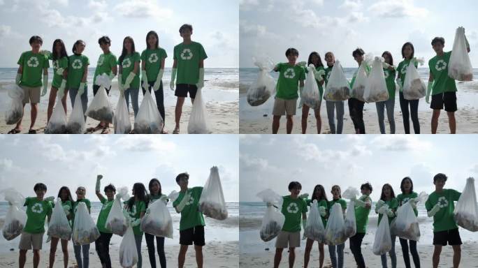 一群快乐的志愿者在海滩上清理垃圾袋。志愿服务、慈善、清洁、人和生态理念