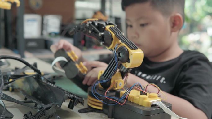教育主题：数字平板电脑上的男孩控制机器人手臂，科学工程，教育，技术