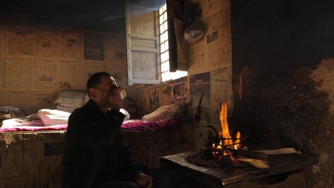 农村老人在老房子里的火盆里喝罐罐茶
