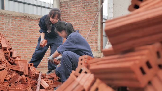 亚洲两个十几岁的女孩一起志愿建造一个住房项目。青少年活动家