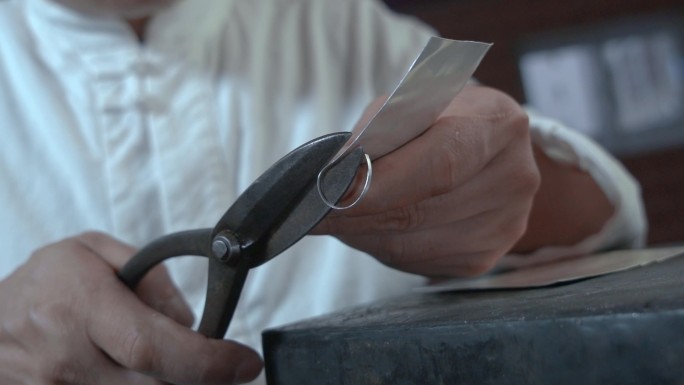 手工艺视频手工匠人锻银雕刻剪切银板慢镜头