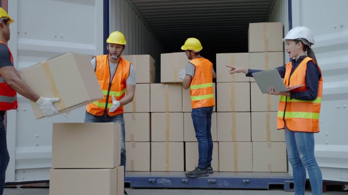工人们正在帮助将货物装入集装箱。