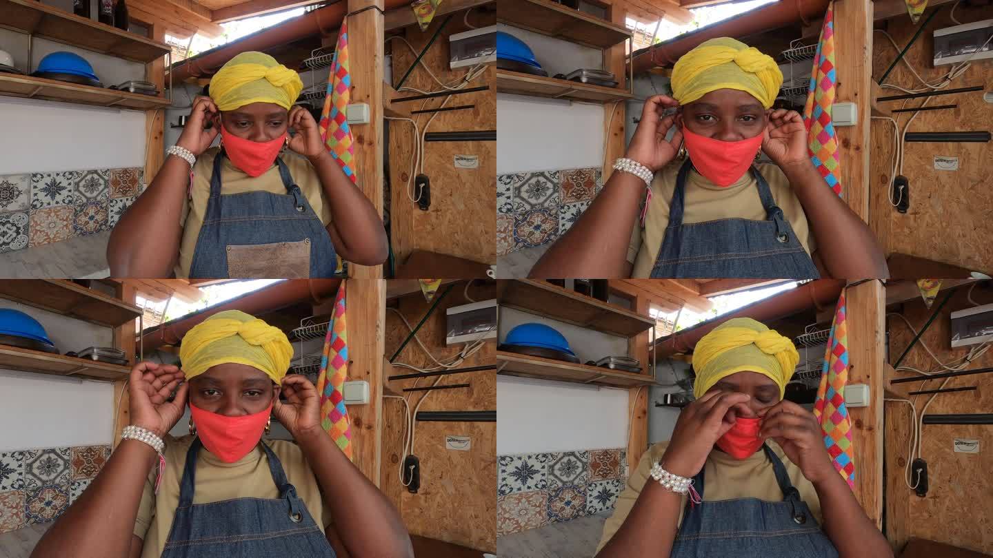 4K视频，非洲裔妇女在共享室外厨房戴上防护面罩