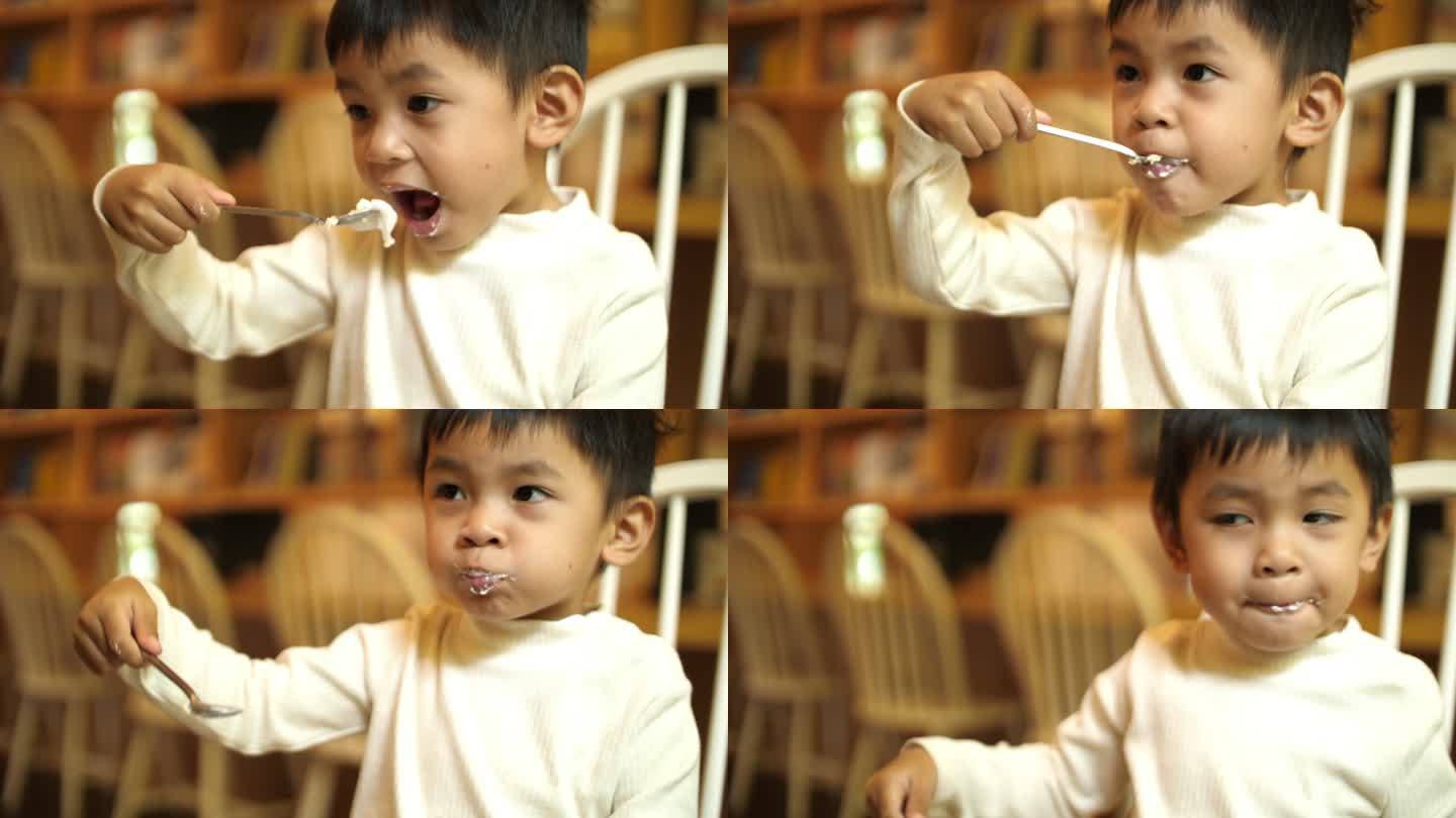 亚洲男婴在咖啡馆吃蛋糕