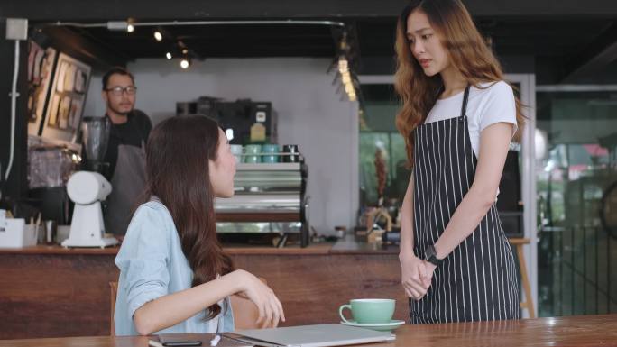 亚洲女顾客向女服务员抱怨咖啡馆的食物，咖啡店的客服不满意