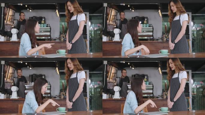 亚洲女顾客向女服务员抱怨咖啡馆的食物，咖啡店的客服不满意