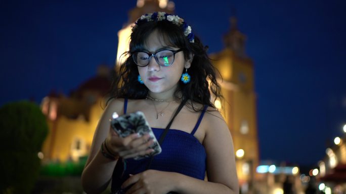 年轻女子使用智能手机在街上行走