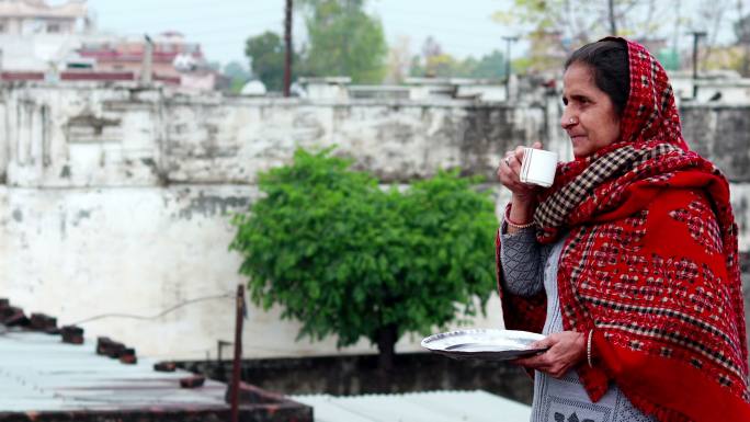 农村成熟的印度女人在清晨喝茶