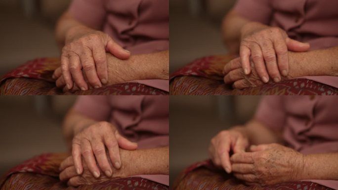 女老人手疼，按摩手，疼痛，手掌，情绪压力，健康概念。慢动作