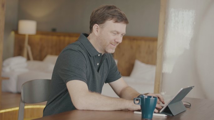 男子在享用早晨咖啡时使用数字平板电脑
