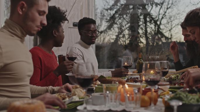 朋友们在圣诞晚餐中享用红酒和美味的食物