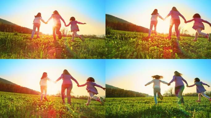 SLO MOTS女子和她的两个女儿在阳光明媚的草地上牵手跑步