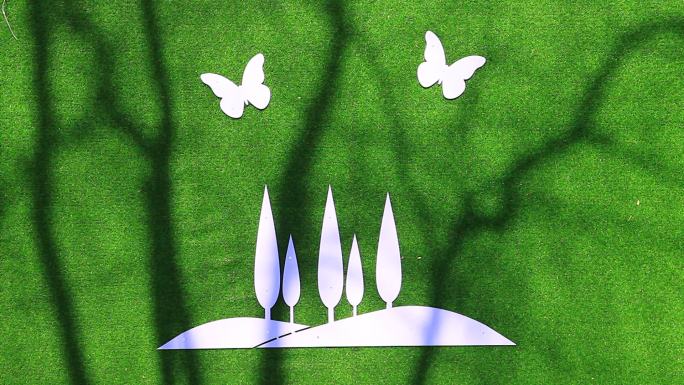 蝴蝶盘旋在一片树林上方造型绿底白色标牌