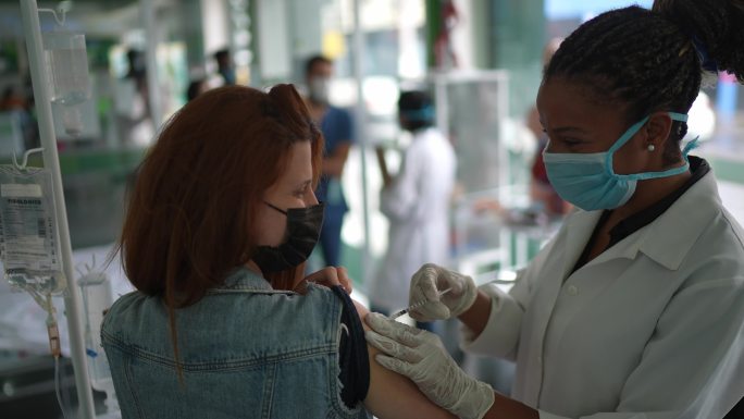 年轻女子在医疗诊所接种疫苗