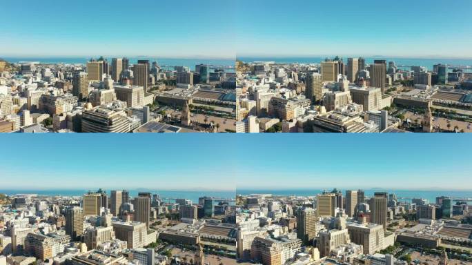 在阳光明媚的日子里，一座现代化城市在海边的鸟瞰图，清晰的蓝色天际线。开普敦的高楼、摩天大楼、公寓和办