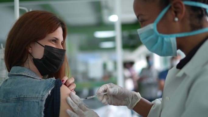 年轻女子在医疗诊所接种疫苗