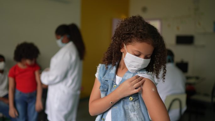 一名女孩接种疫苗后露出手臂的照片