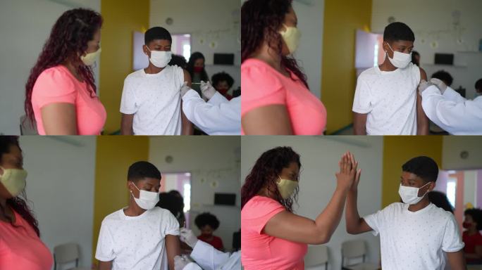 男孩在接种中心与母亲一起接种疫苗