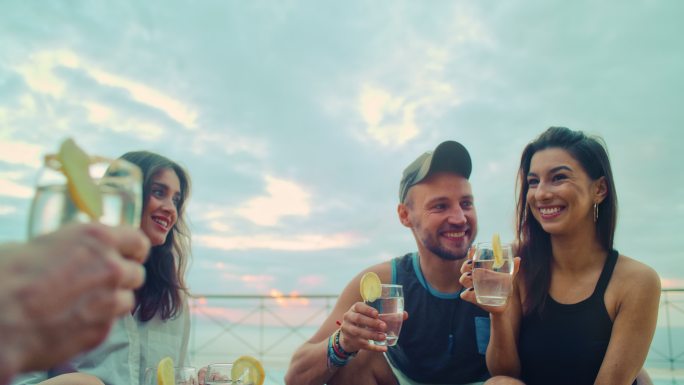 派对上的夏日祝酒词。在热带气候的露台上享受饮料的朋友