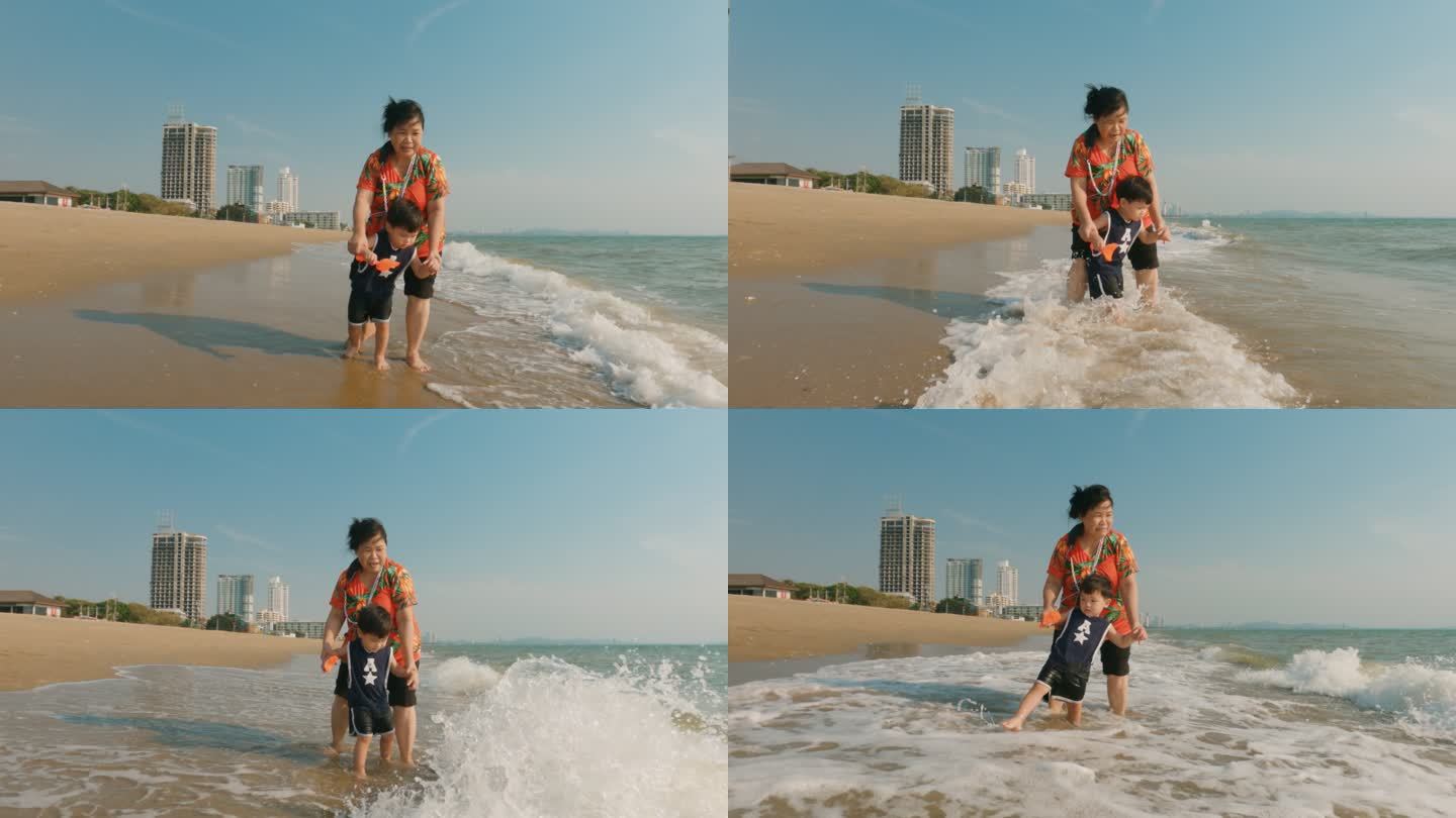 在漫长的周末，快乐的亚洲家庭在海滩上享受时光。