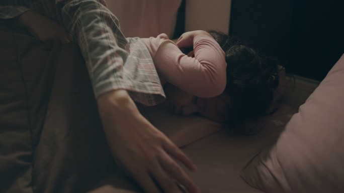 亚洲婴儿或女孩晚上与母亲在卧室睡觉。她整天玩累了