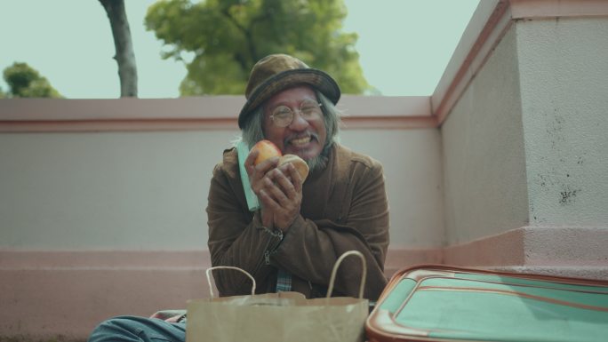 饥饿的无家可归者戴着口罩吃苹果。