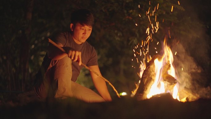 Asain Man在森林中点燃篝火