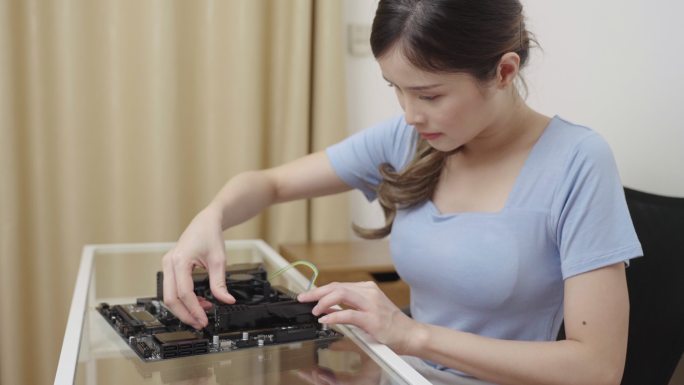 在计算机主板上安装或修复随机存取存储器（RAM）的女性。