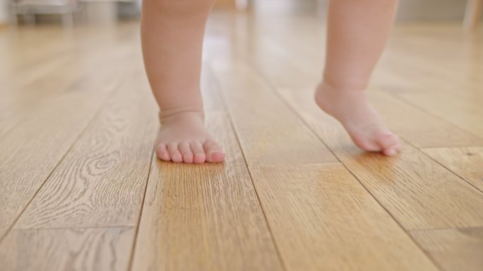 SLO MO婴儿赤脚在木地板上行走