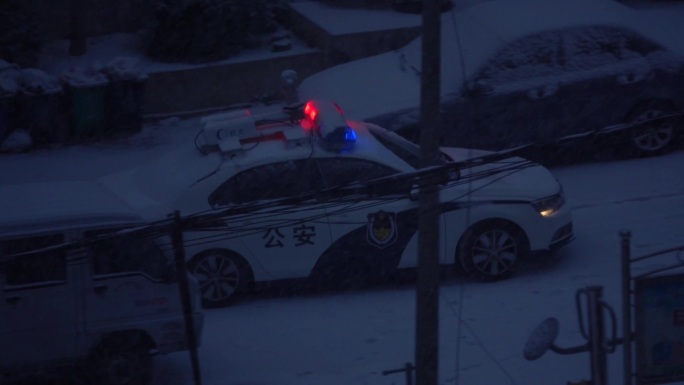 下雪天在路上巡逻的警车