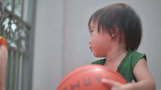 夏季周末，亚洲中国男婴在家门口打球