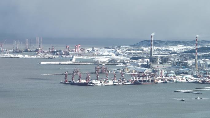 长焦航拍雪后海岸上的威海华能电厂和港口