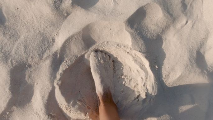赤足脚趾间热带白色沙滩的POV