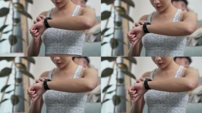 年轻的亚洲女性在锻炼前设置智能手表。