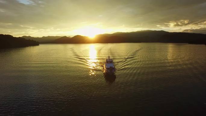 波光粼粼的金色湖面上行驶的轮船