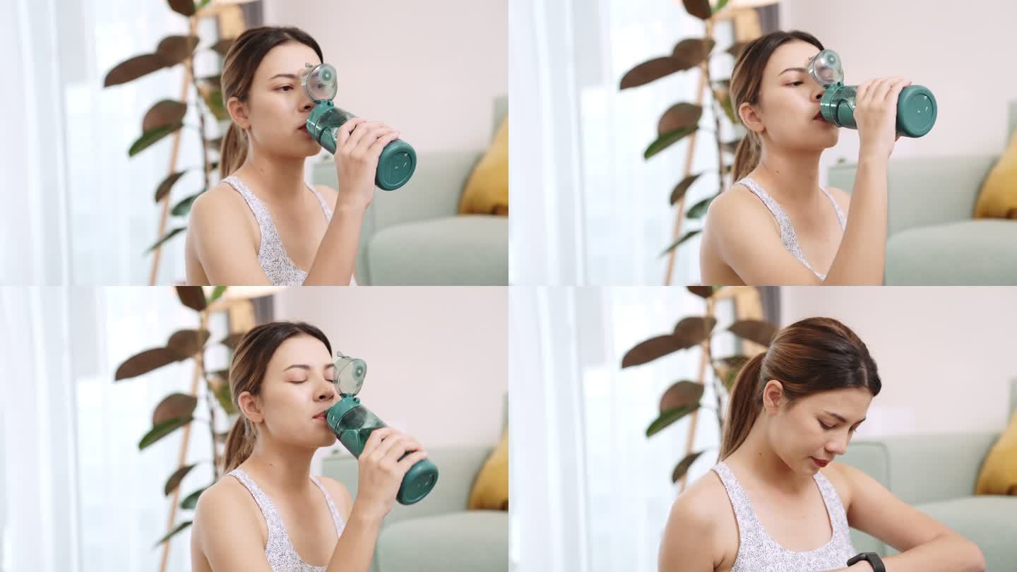 健康女性在家锻炼后喝水