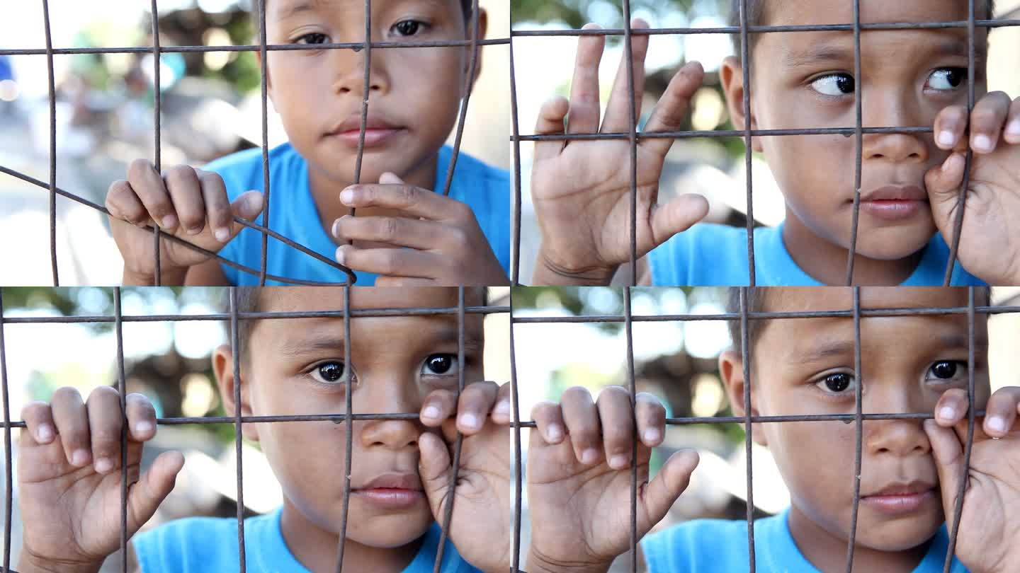 贫困-围栏后面的亚洲男孩