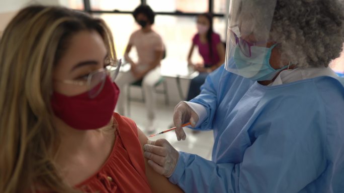 青少年女孩正在接种疫苗-戴口罩