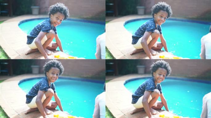 男孩在游泳池里用水枪射击的照片