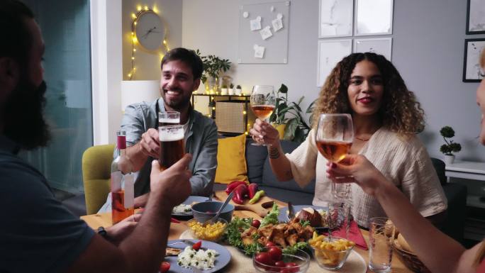 朋友和家人吃晚餐，喝葡萄酒。庆祝祝酒辞，喝葡萄酒和啤酒