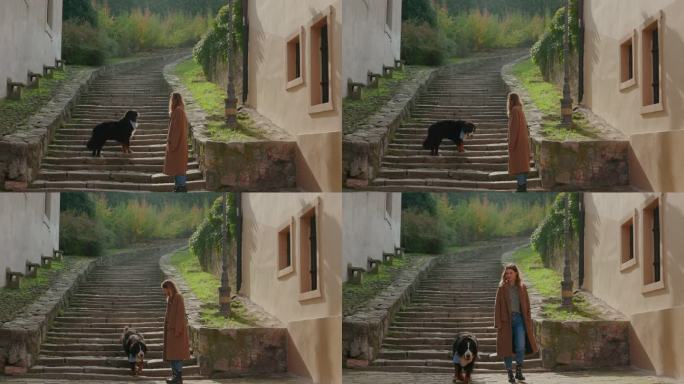 女人和宠物狗在鹅卵石楼梯前散步
