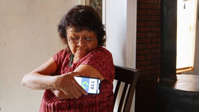 老年女性在应用程序上检查血糖水平