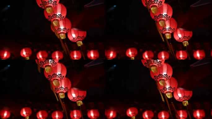 夜晚，古老的传统寺庙上挂着圆形的红色灯笼。