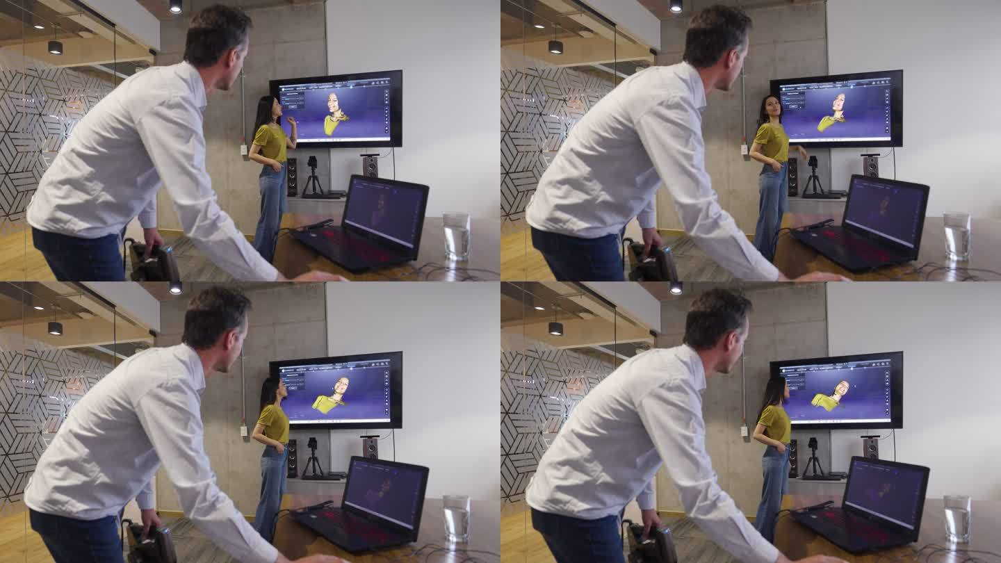 一名在3D打印工作室工作的男子与一名女同事在讨论某件事时正在查看她的扫描结果