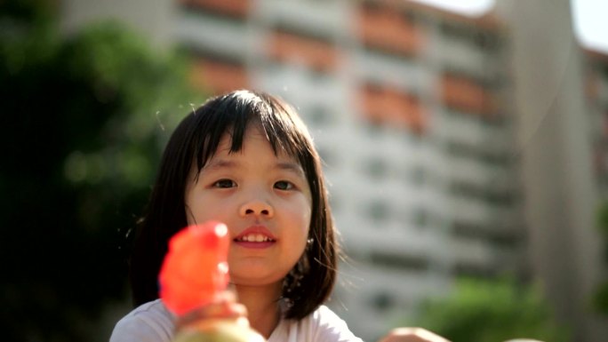 亚洲女孩玩水枪外国人小孩童年开心夏天玩水